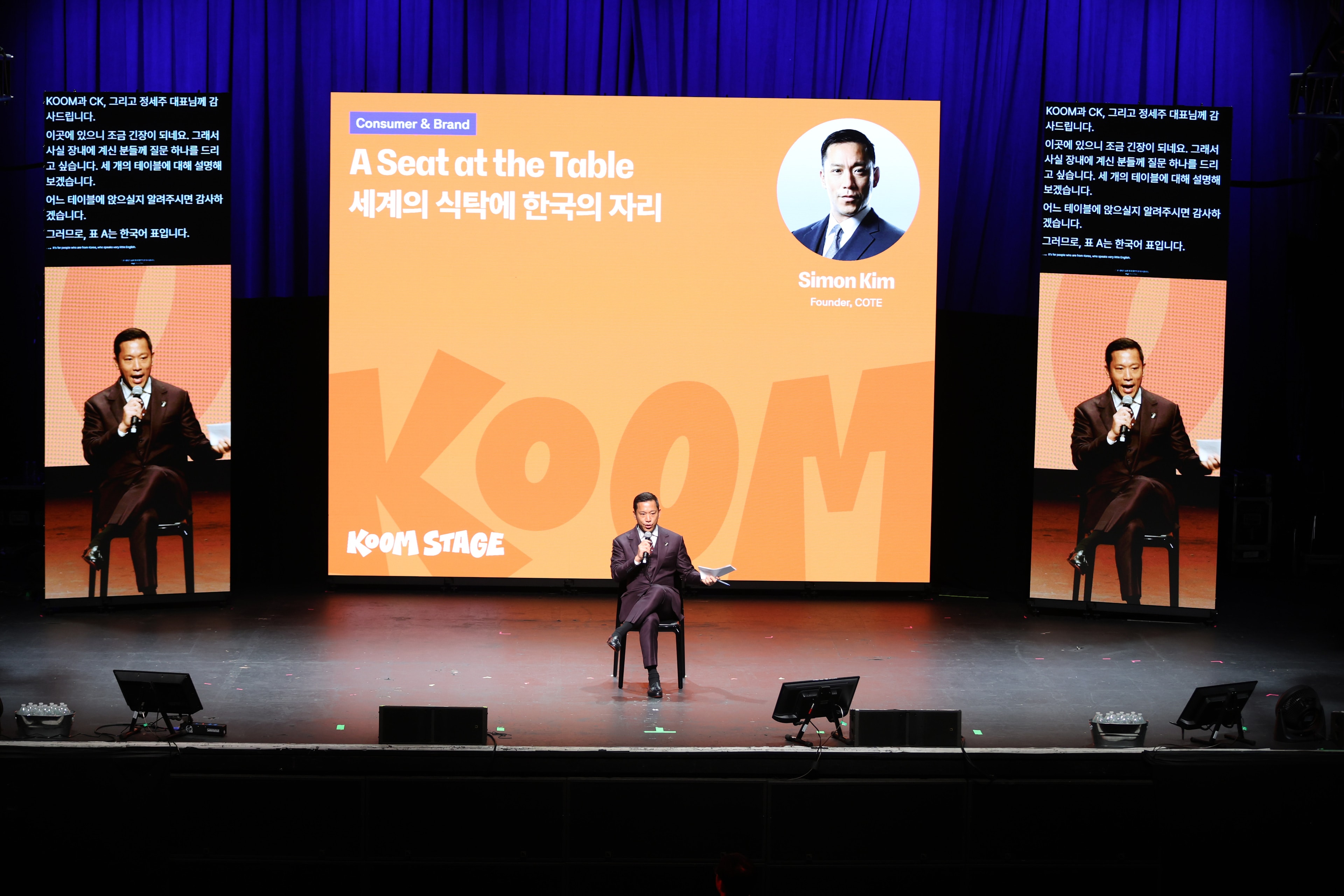 A speaker presenting on the KOOM Stage